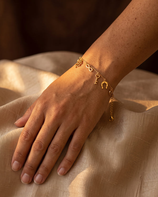 Pulsera oro 9k con amuletos y borlas